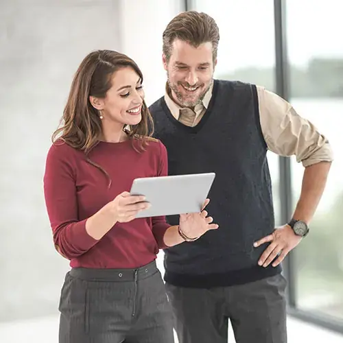 Colleagues reviewing a tablet together in a bright office